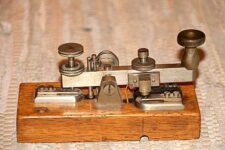 Image of an antique morse key, mounted on stained wood